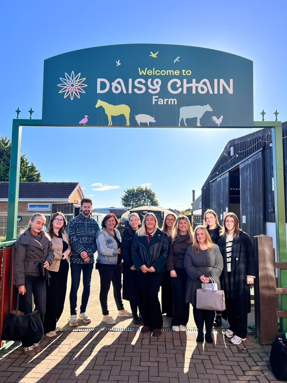 Cygnet Law staff outside the entrance to Daisy Chain Farm