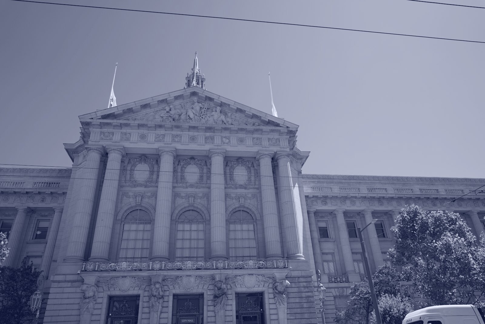 The neoclassical facade of San Francisco City Hall under a clear blue sky