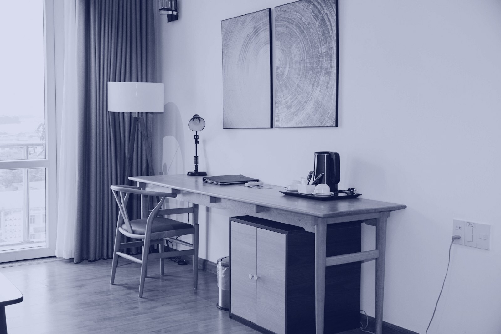 A wooden desk with a chair and lamp