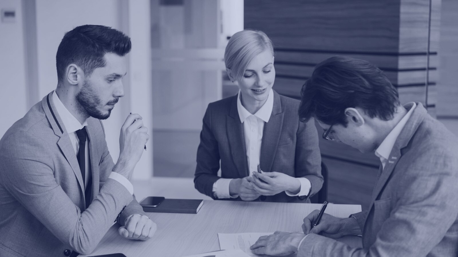 Business people signing a contract at a table