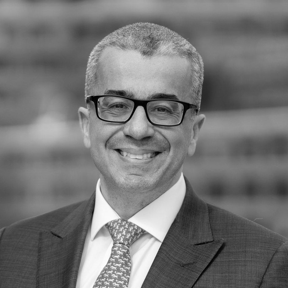 Headshot of smiling man with glasses in blue suit