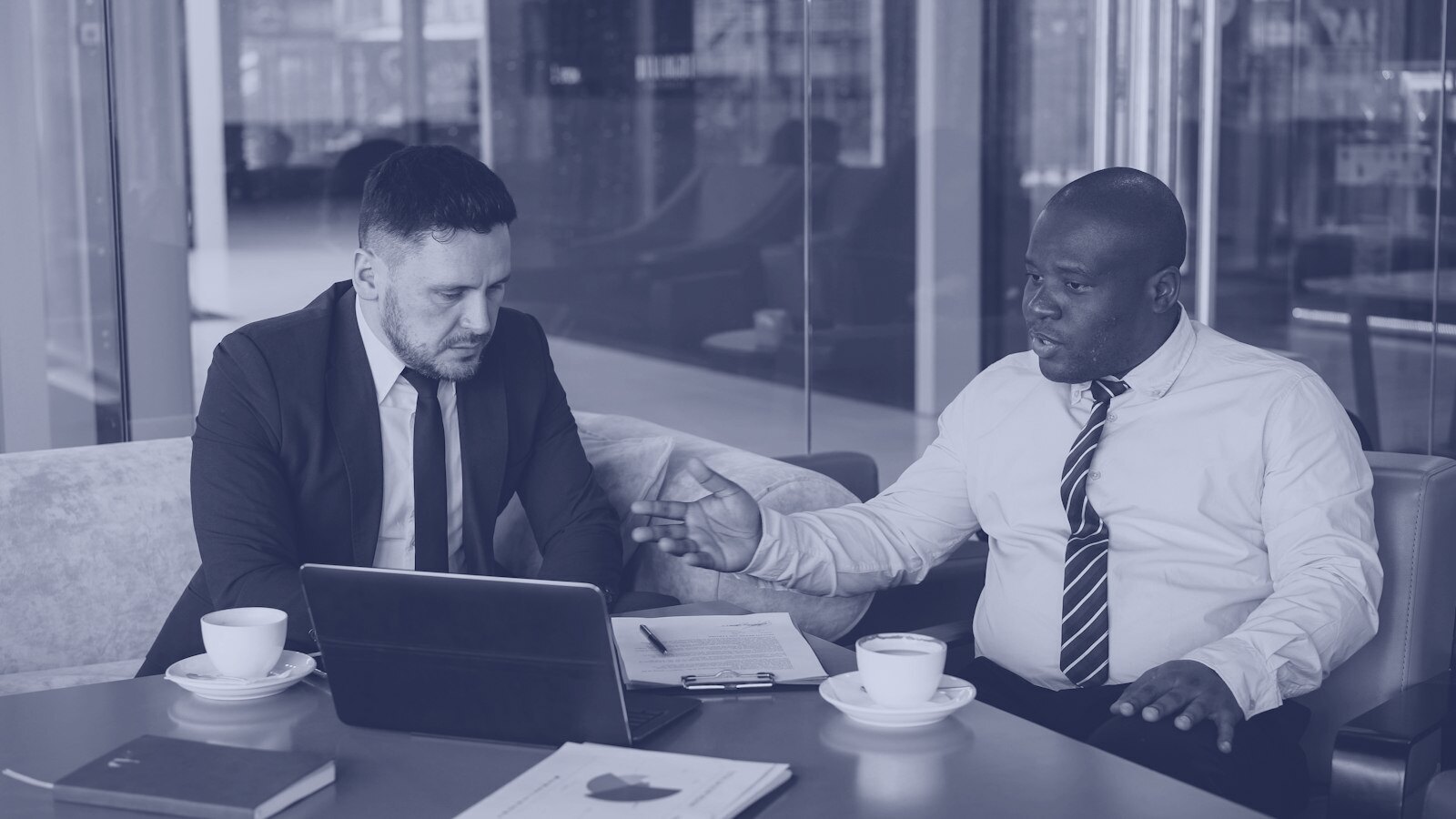Two businessmen discussing a project at a table